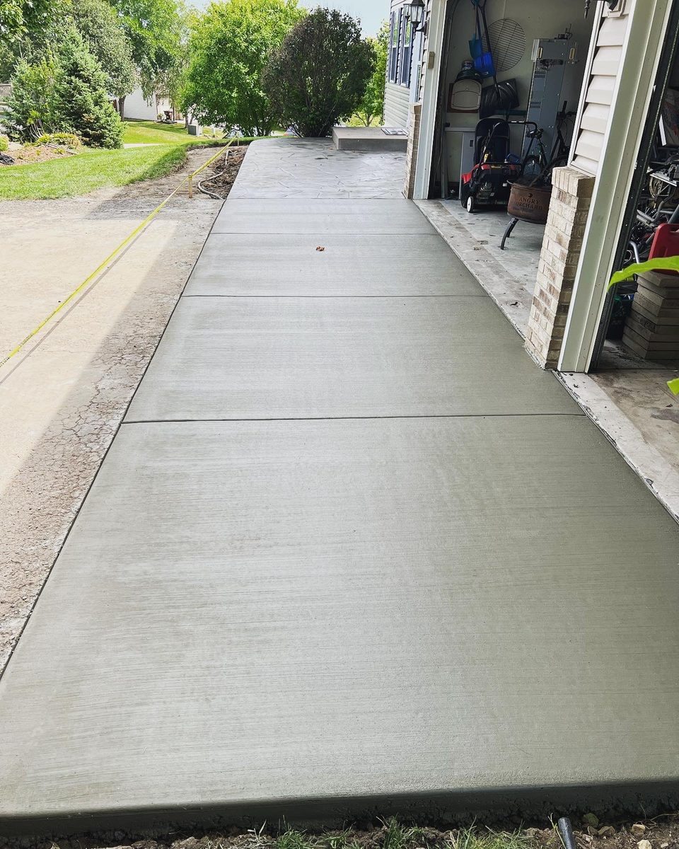 Broom-finish concrete driveway approach running into an open garage
