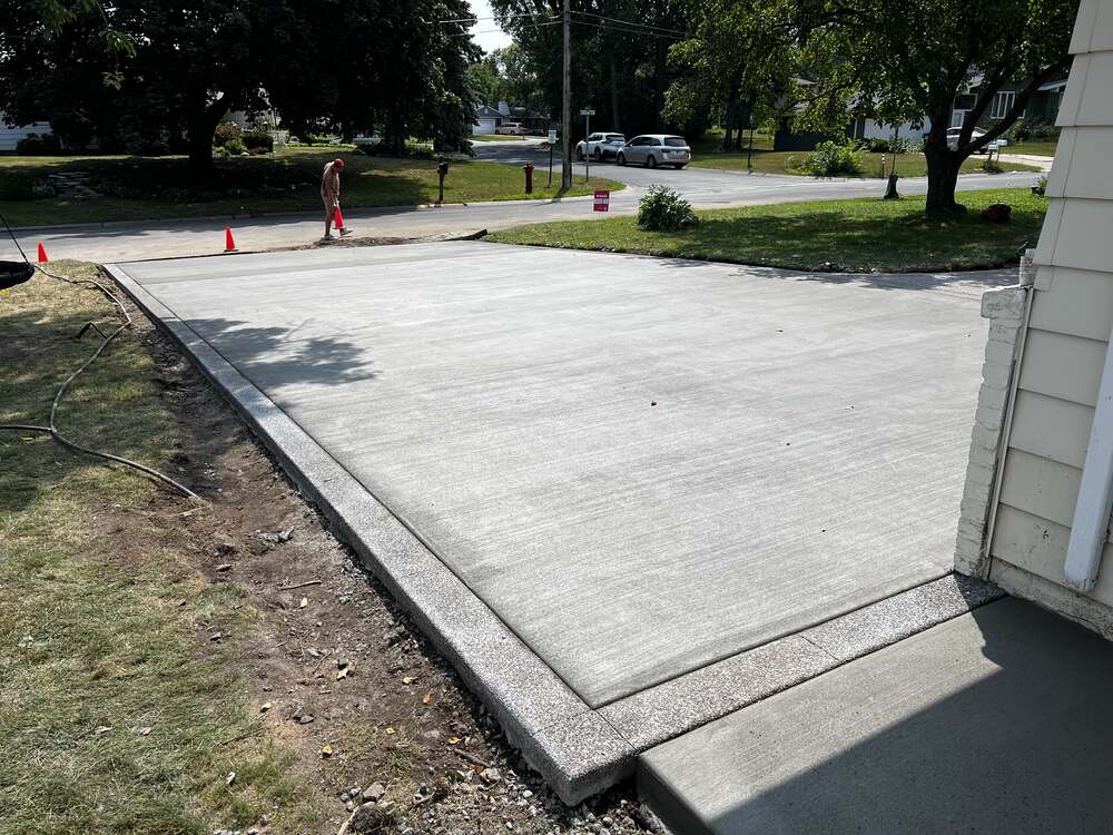 Fresh broom-finish concrete driveway with exposed aggregate border in Columbia Heights, MN
