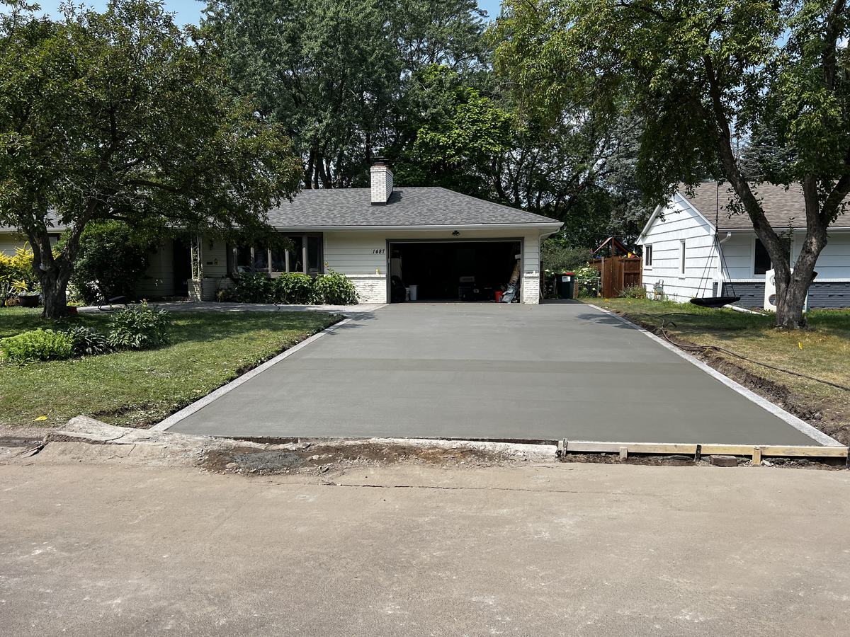 Concrete driveway freshly poured and floated in its forms in Columbia Heights, MN