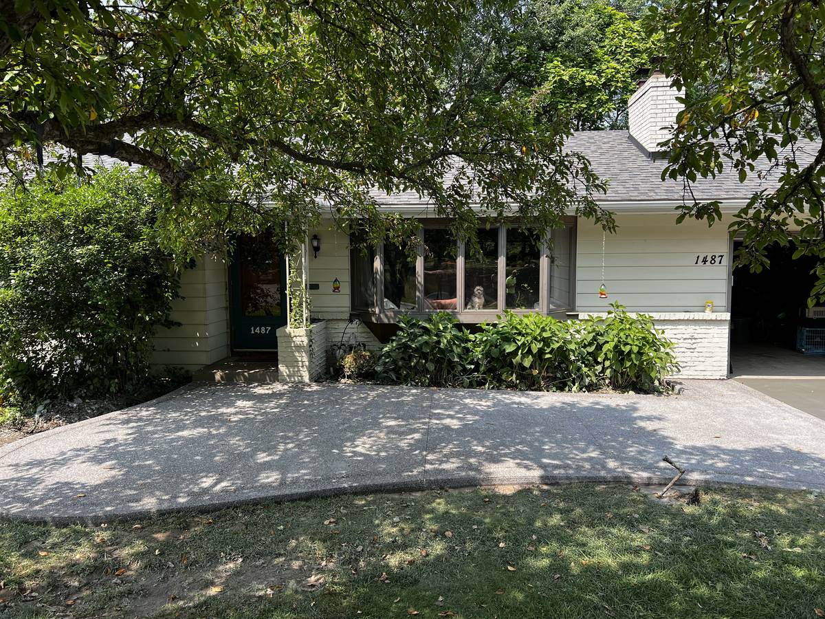 Exposed aggregate concrete driveway sweeping across the front of a rambler in Columbia Heights, MN