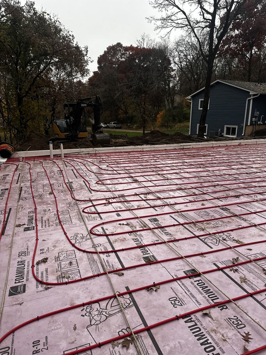 Radiant heat tubing tied over rigid foam insulation before a concrete slab pour