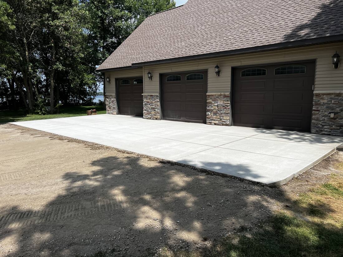 Completed concrete apron and parking pad at a three-stall garage